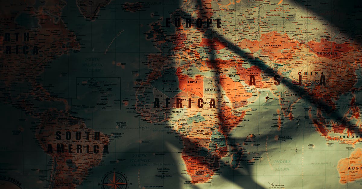 Cheapest season to go to South Africa from North America - From above of sunlit aged paper world map with continents countries and oceans