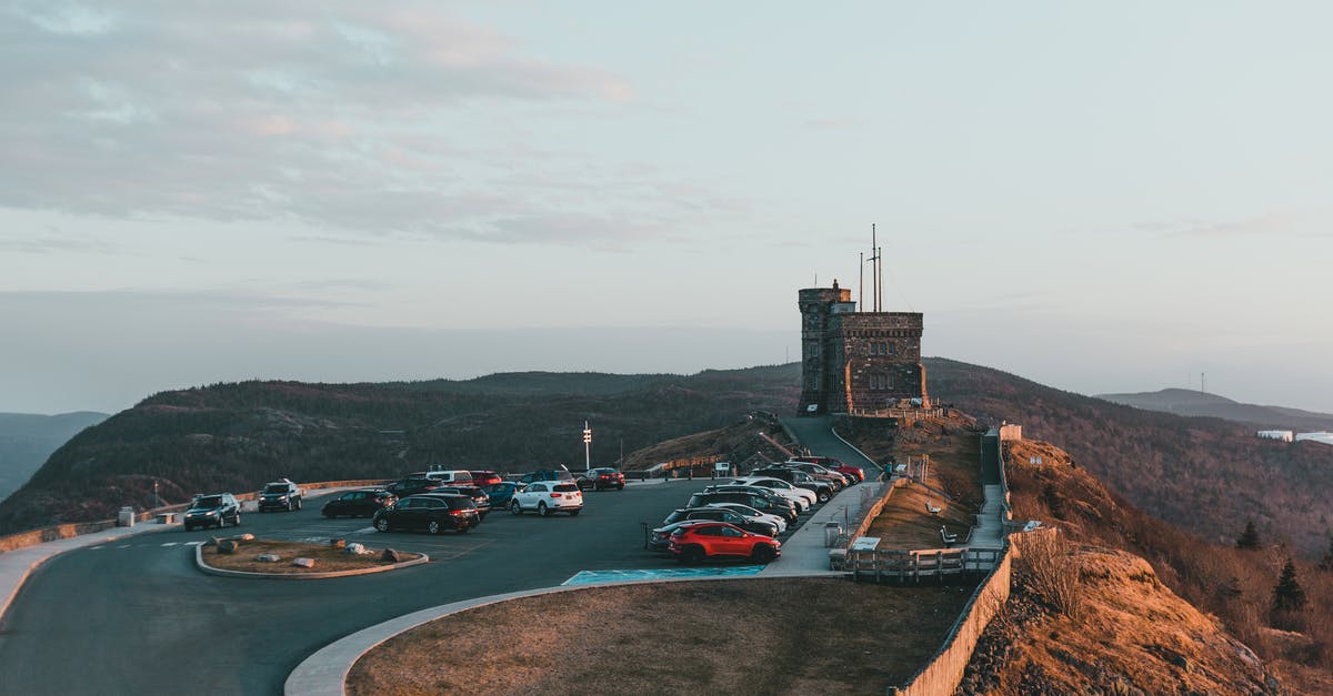 Cheapest way of shipping my car from Canada to Europe? - Automobiles parked on asphalt road near famous historic stone fortification located on grassy Signal hill in nature against cloudy sky