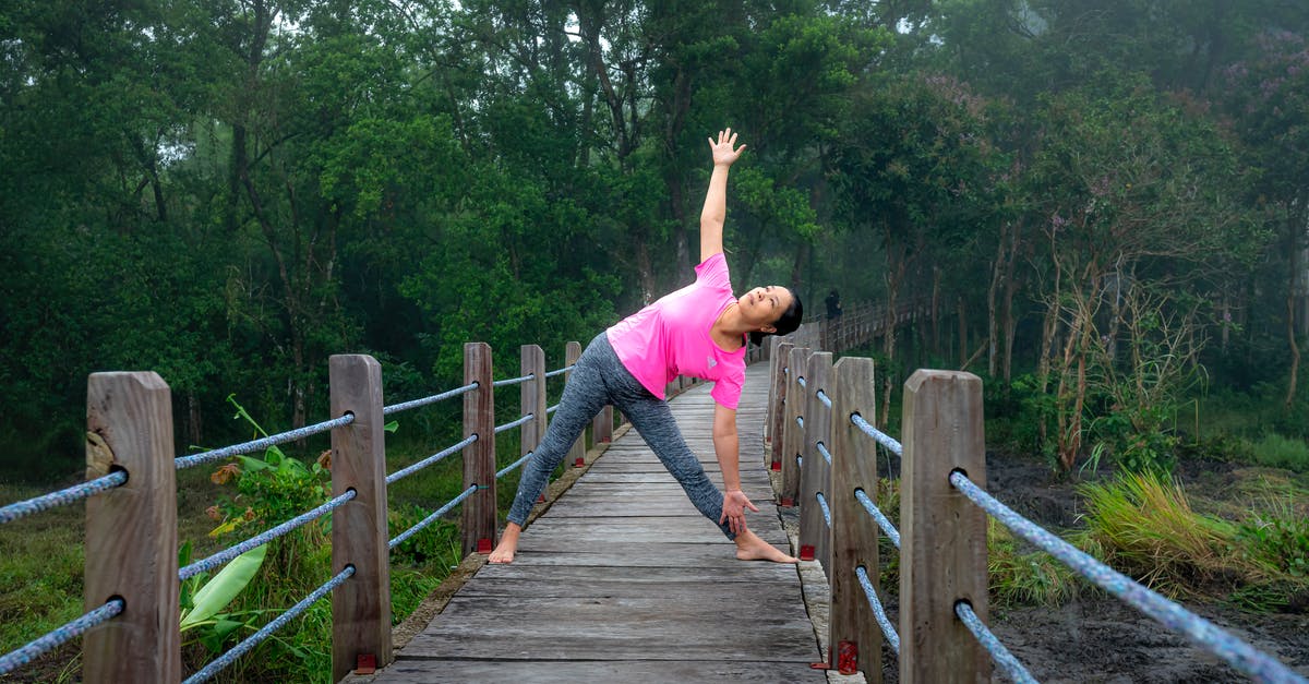 Cheapest Way to Get to Europe--I'm Flexible [duplicate] - Peaceful woman practicing Trikonasana pose in nature