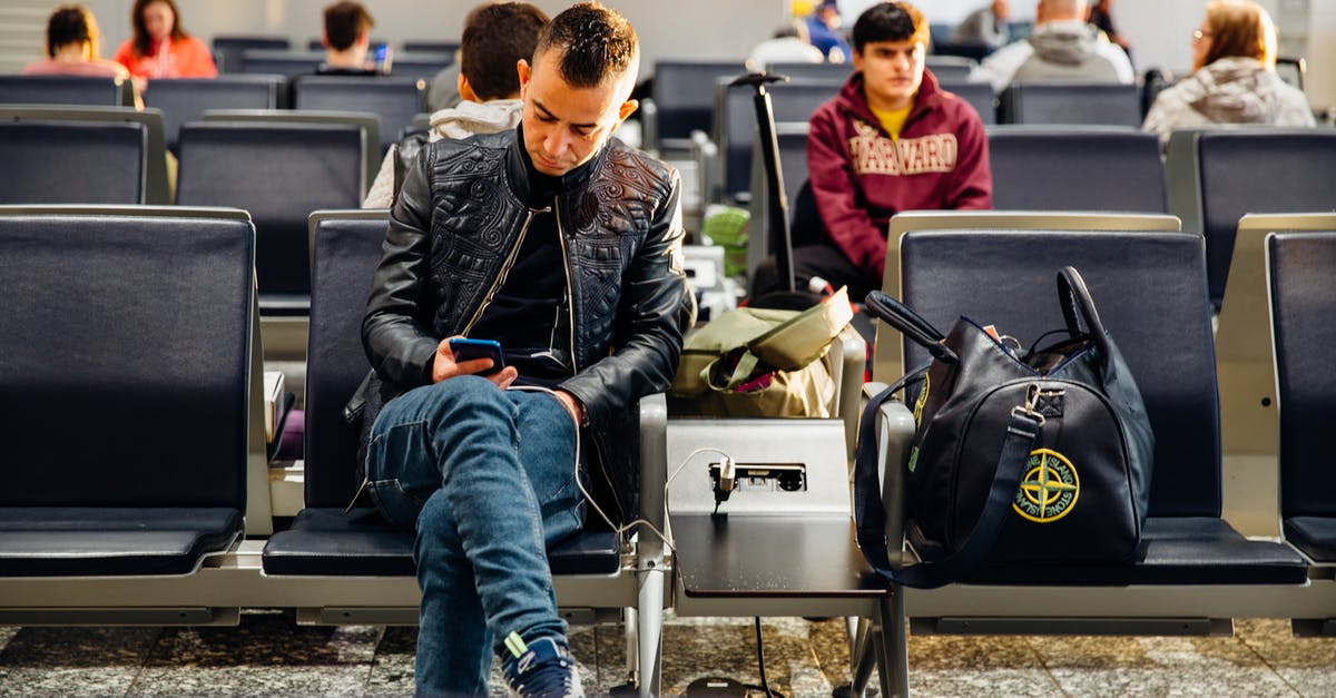 Check in cabin bag at Dublin Airport with Aer Lingus - Man in Black Leather Jacket Sitting on Chair