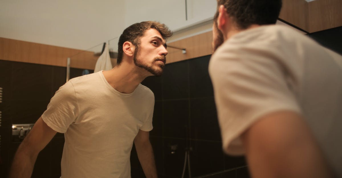 Check in of guests who didn't make the reservation [closed] - Stylish concentrated man looking in mirror in bathroom