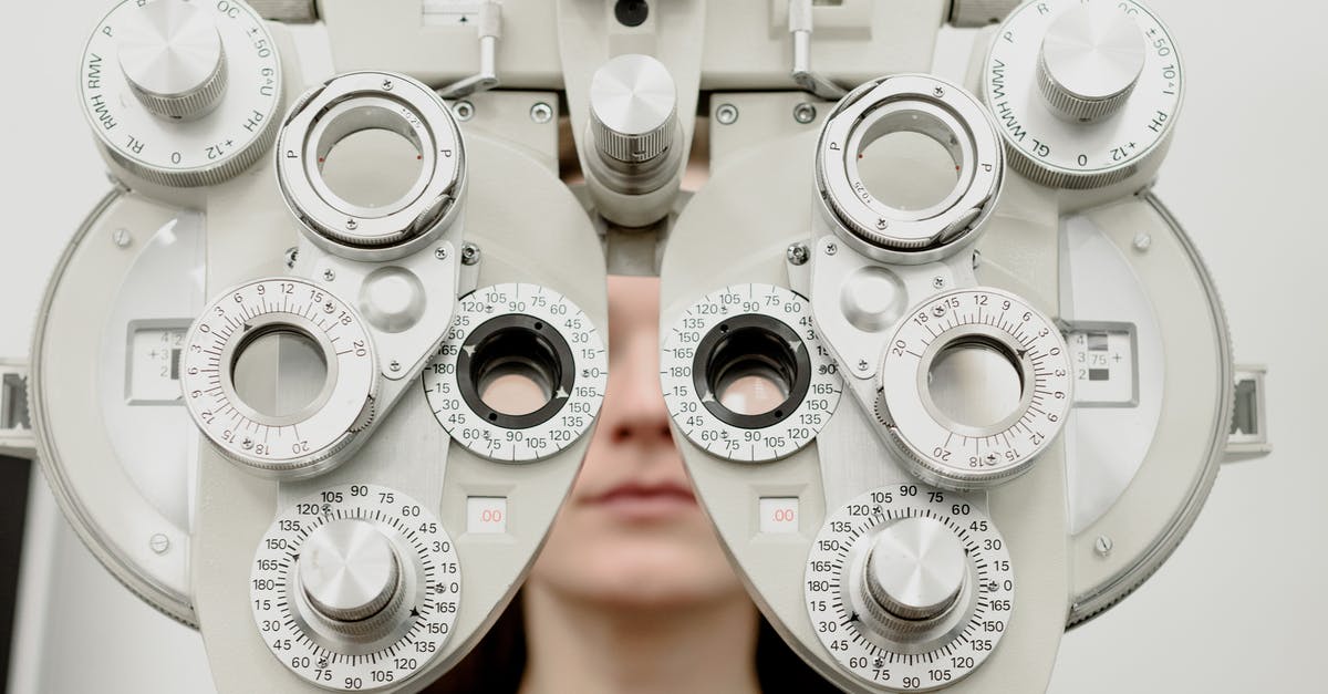 Check UK visit visa status in Ukraine [closed] - Woman diagnosing vision on refractor testing device during eye examination in modern ophthalmology clinic