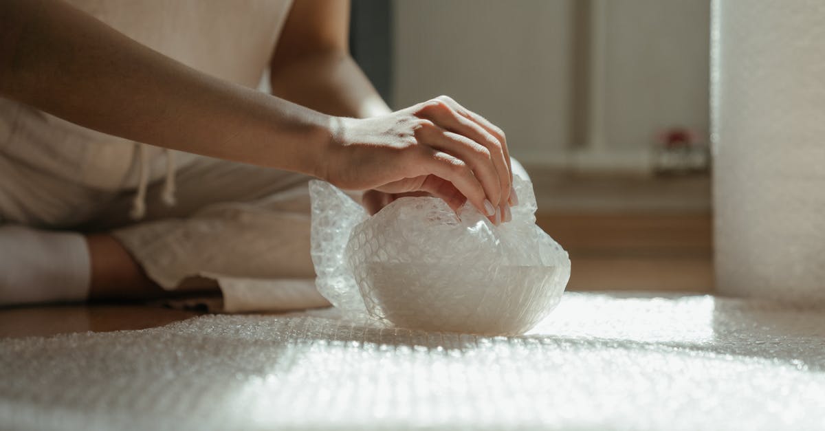 Checked baggage bubble wrapped only - Person Holding White Plastic Bag