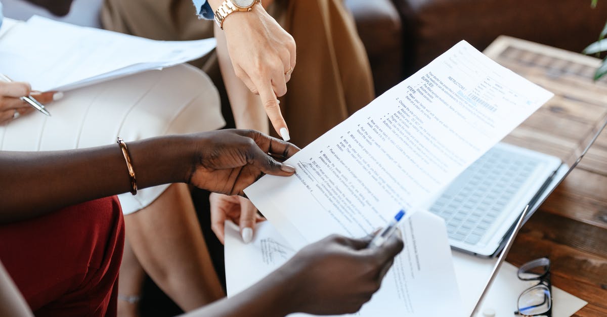 Check-in of hand luggage - Multiethnic businesswomen checking information in documents