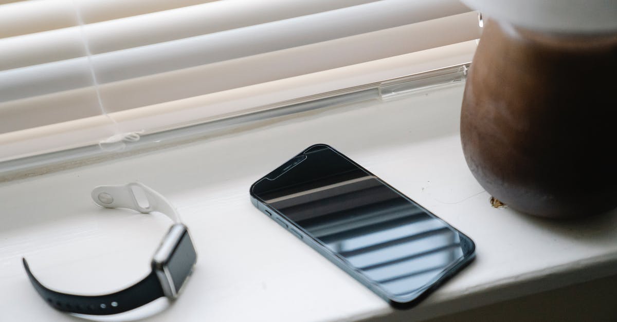 Check-in time for early morning flight from Minneapolis–St Paul - Smartphone and wristwatch on windowsill near lamp