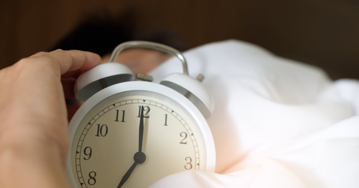 Check-in time for early morning flight from Minneapolis–St Paul - Photo of Person Holding Alarm Clock