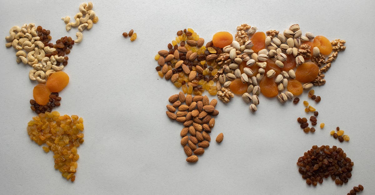 Check-in when travelling with two different companies - Top view of creative world continents made of various nuts and assorted dried fruits on white background in light room