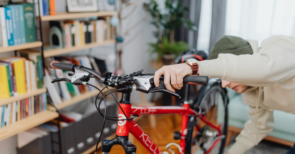 Checking a hire bike is properly docked - A Man Checking a Red Bicycle