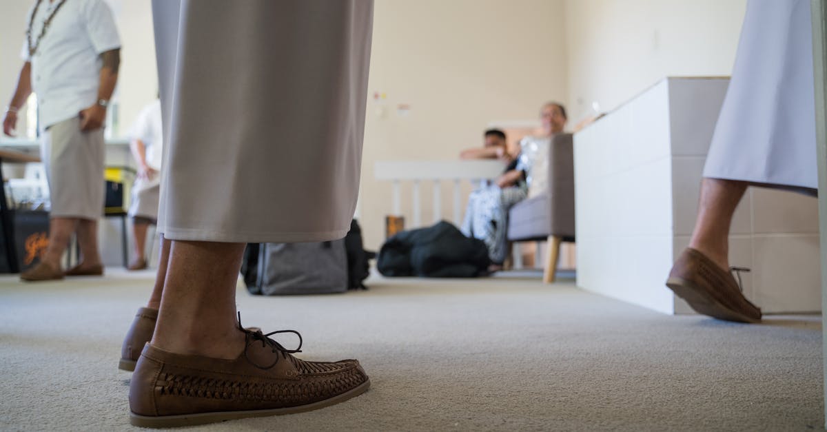 Checking In Luggage During Intermediate Leg [duplicate] - Crop people in room with anonymous men