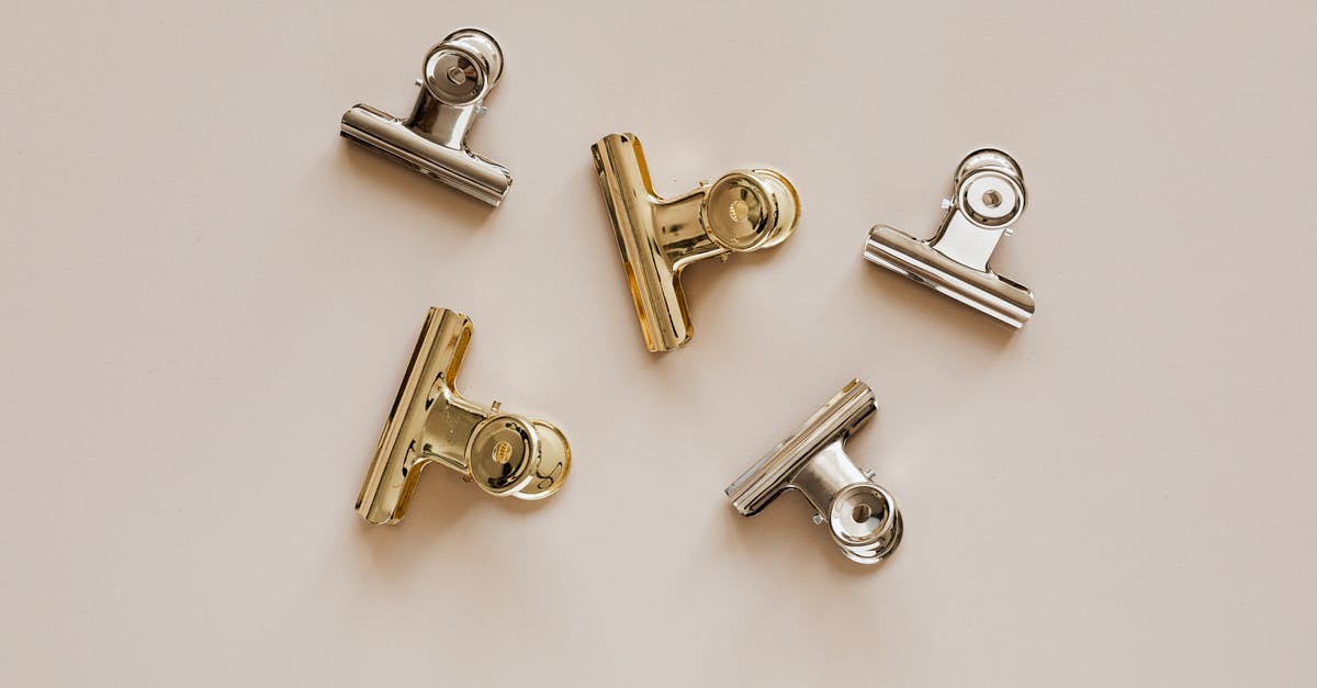 Checking small items on a plane? - Set of metal clips on beige background