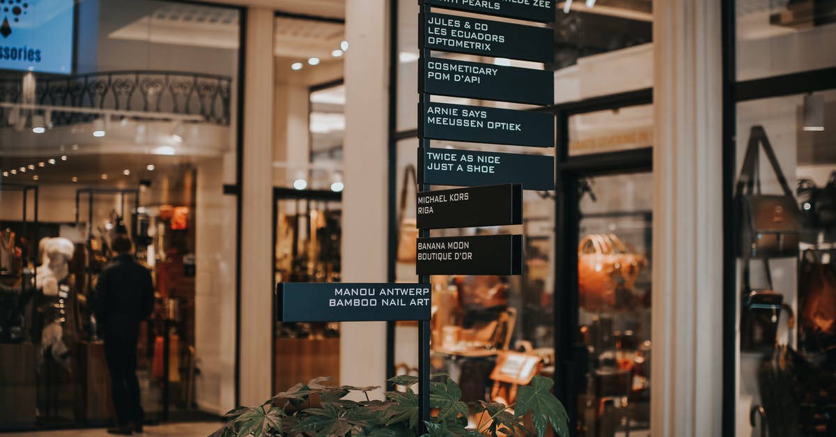 Checking-in bags to different destinations when flying with a layover - Signboard located near store with various goods