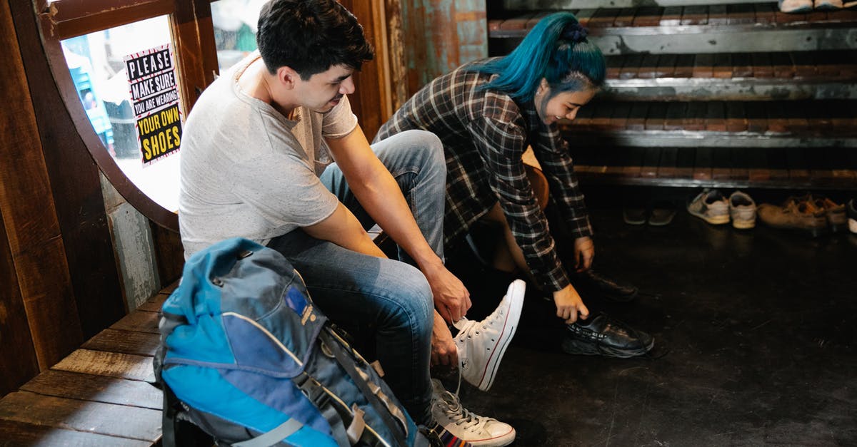 Checking/stowing luggage in London for a stopover visit [closed] - Young diverse couple of travellers taking off shoes