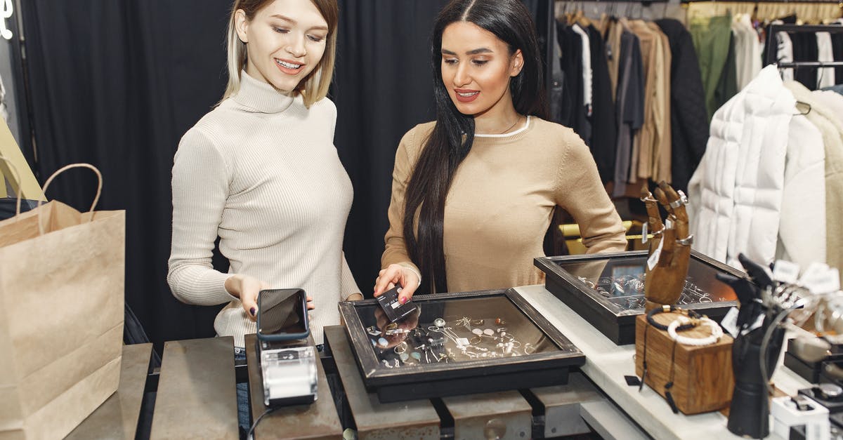 Chicago CTA pass on contactless bankcard or Apple Pay - Women paying for clothes with smartphone