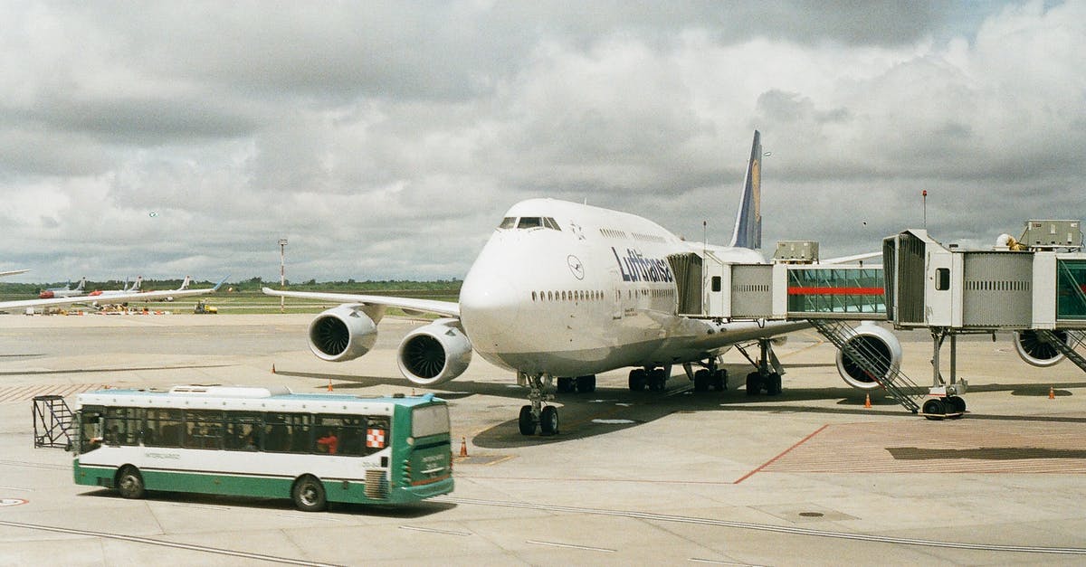 Chicago Midway airport (MDW) feasibility to/from Greyhound Bus station? - Plane on Airport with Telescopic Corridor Attached and Bus Driving in front of It