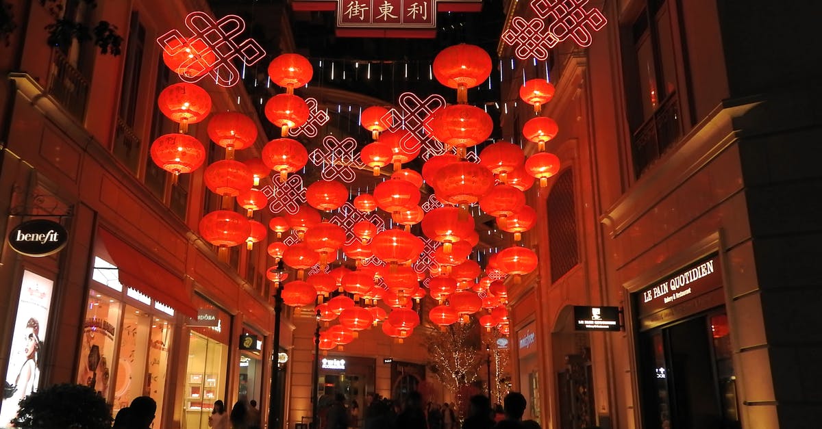 Chinese tourist L visa and visiting Hong Kong - Traditional Chinese lanterns hanging in street between buildings with people