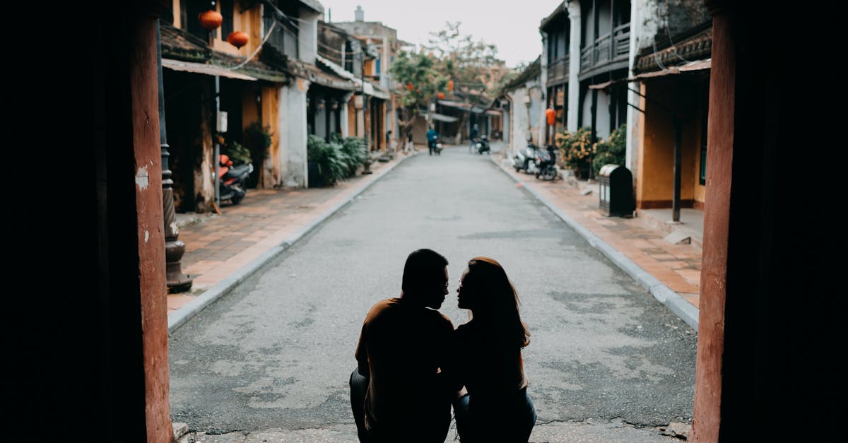 Chinese visa free with 2 passports - Back view of anonymous couple looking at each other on Chinese street in daytime