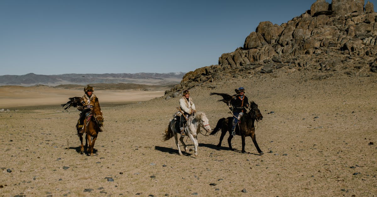 Chinese/Spanish dual national entering Schengen area - Ethnic people on horses near rocky formation