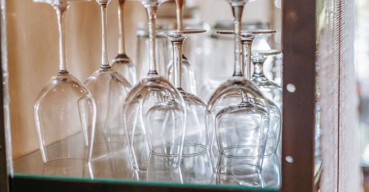 Classic Aussie pub (hotel) in central Sydney - Many wineglasses placed upside down on glass shelf in cupboard in light modern restaurant