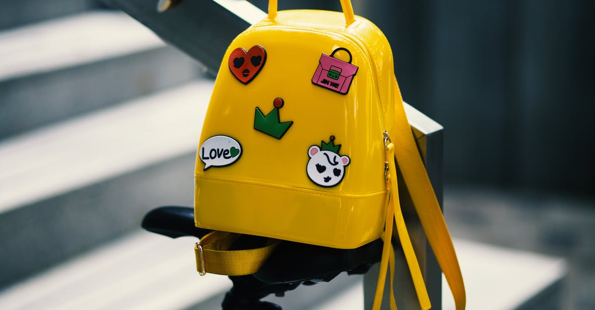 Clear backpack bags on Icelandair - Yellow Backpack With Five Assorted Stickers on Grey Metal Stairway Rail
