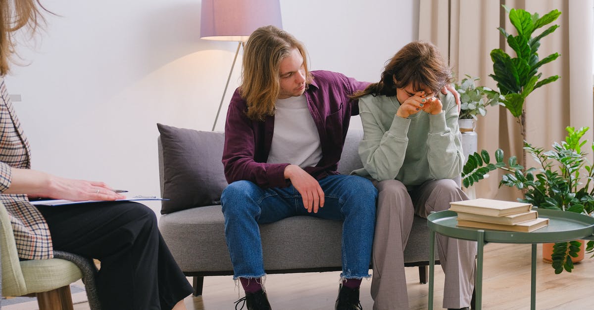 Coded Landing Help [closed] - Young male embracing frustrated girlfriend during session with psychologist in light room in daytime