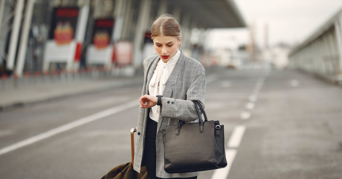 Codeshare flight baggage policy - Worried young businesswoman with suitcase hurrying on flight on urban background