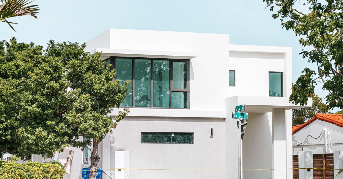 Colombian with a UK residence travelling to Colombia through Miami - White Concrete Building Near Green Tree