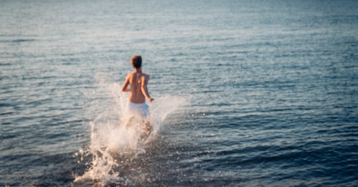 Colombian with EU blue card travelling to the UK - Back View of Man Running in Water