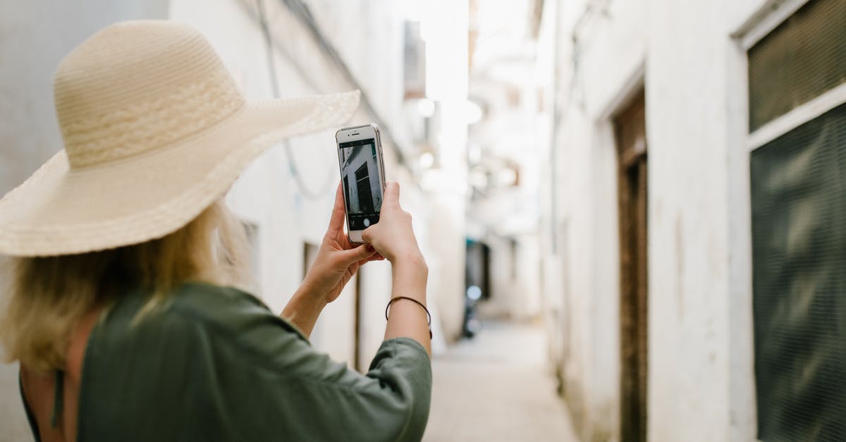 Coming back in US using tourist visa - Woman taking photo of building in alley