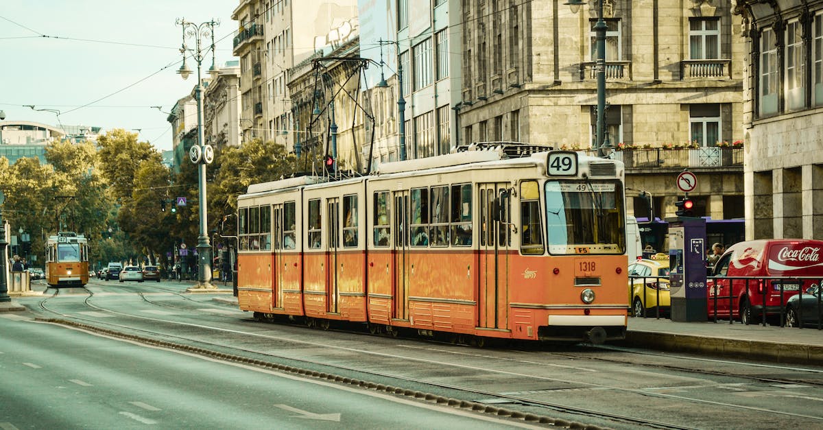 Comparing travel costs in Europe: rail vs bus - White and Orange Train Near City Buildings