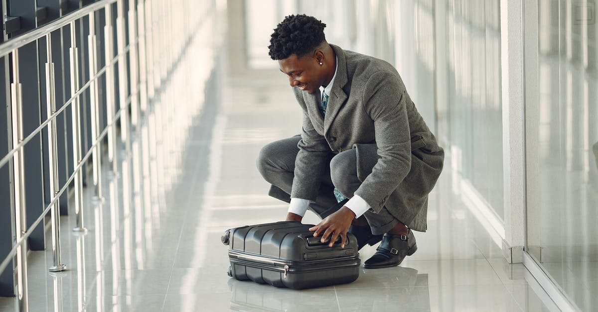 Compensation for denied boarding due to baggage delay - Elegant businessman with suitcase standing in airport hallway