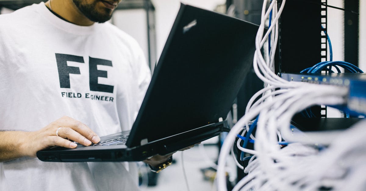 Concerns regarding UK Border Control and no job - Crop focused Asian engineer in white shirt using modern netbook while working with hardware