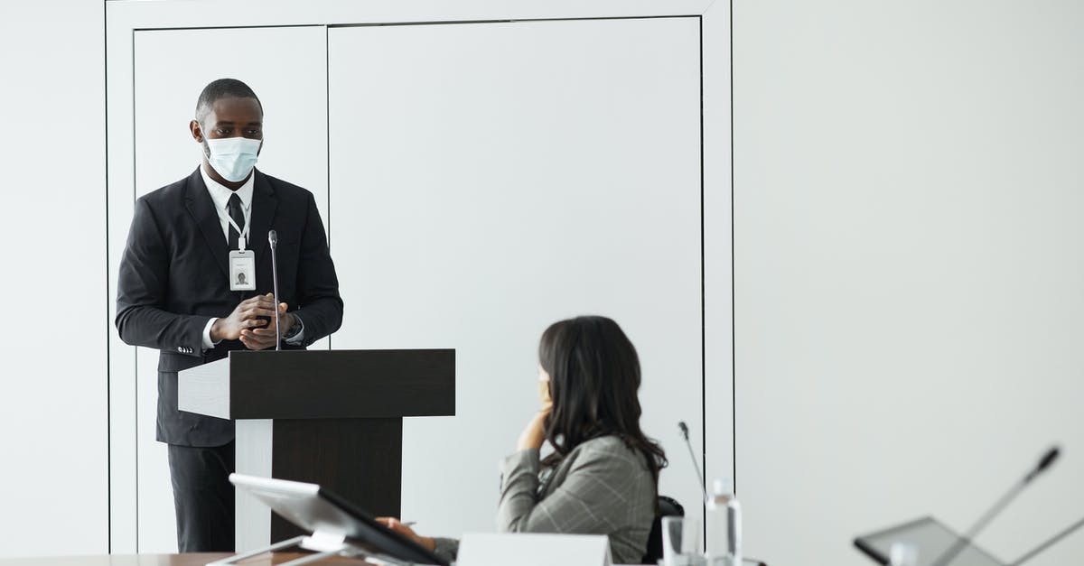 Conference in Los Angeles, visa? - Man in Black Suit Jacket Sitting on Chair in Front of Woman in Black Long Sleeve