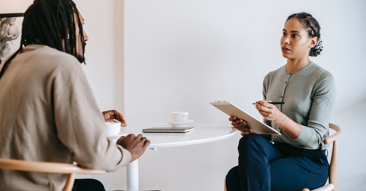 Confirming biometric appointment availability before paying - Ethnic female psychotherapist listening to black clients explanation