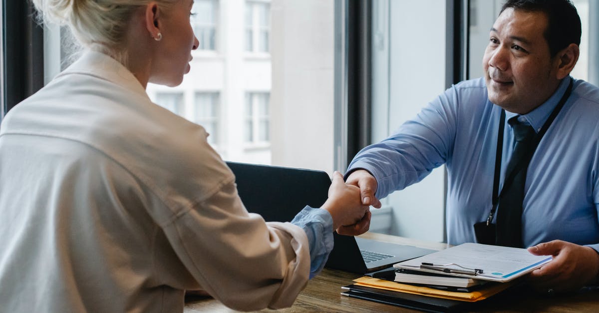 Confirming biometric appointment availability before paying - Ethnic businessman shaking hand of applicant in office