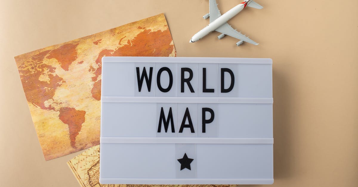 Conflicting information about COVID-era international travel to Russia - Top view of light box with World Map inscription placed near world continents and toy plane on beige background in studio