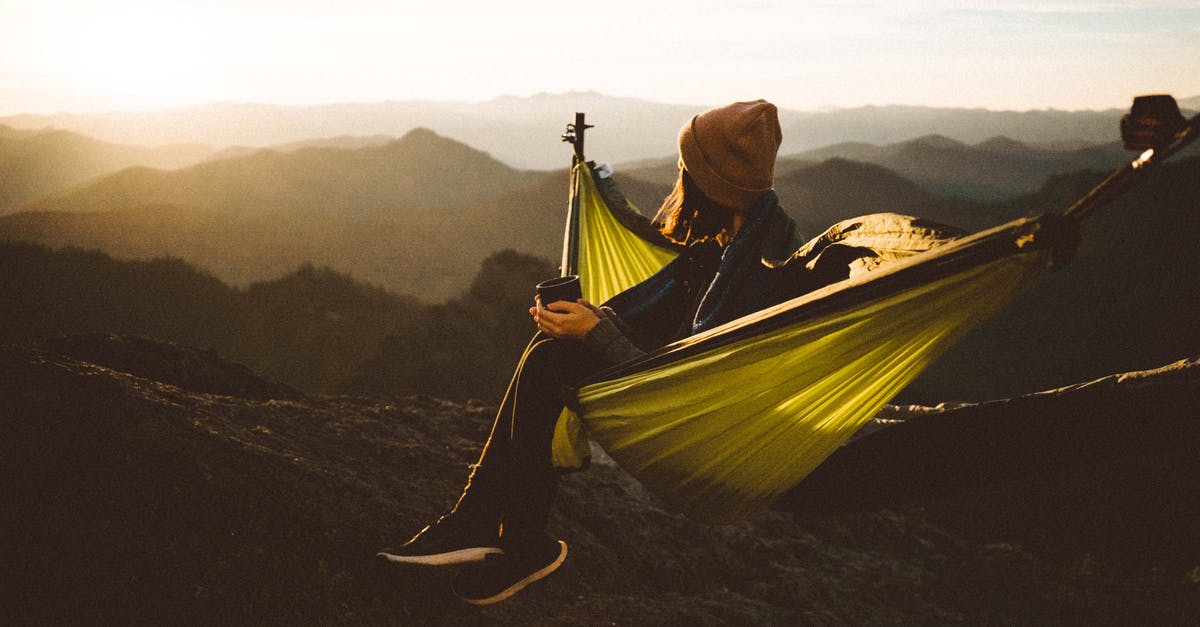 Confusion about off peak timings of London trains - Unrecognizable woman sitting in hammock above mountains