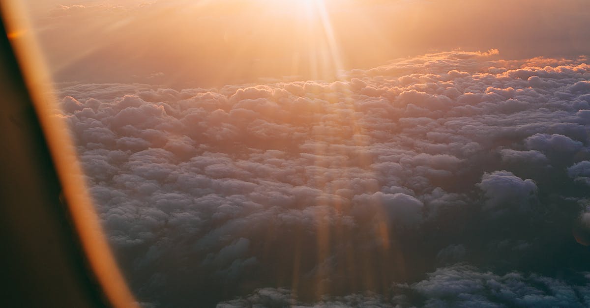 Connecting flight through Dubai with an Israeli/Jewish name - Through plane window of dark endless clouds under bright orange light of sun