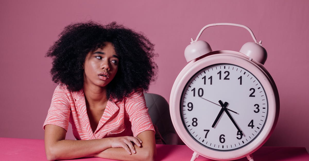 Connecting flight wait time 11 hours 20 minutes - is it possible to exit to see Vancouver? - Woman Looking at a Big Pink Alarm Clock