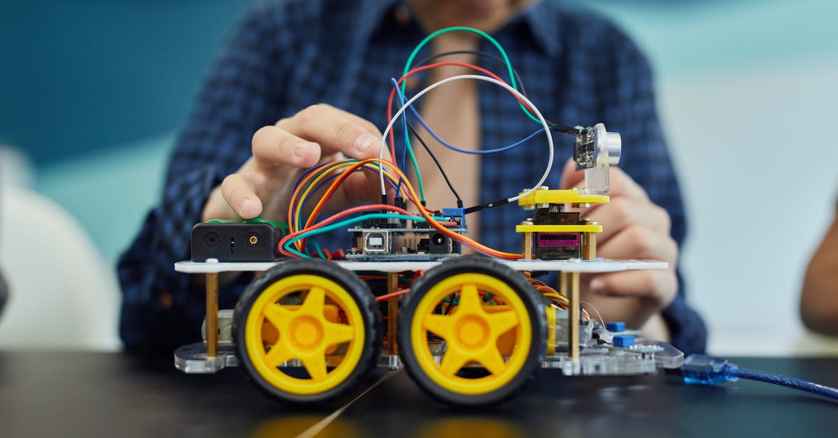 Connecting Flights - A Person Fixing the Wire on Toy Vehicle