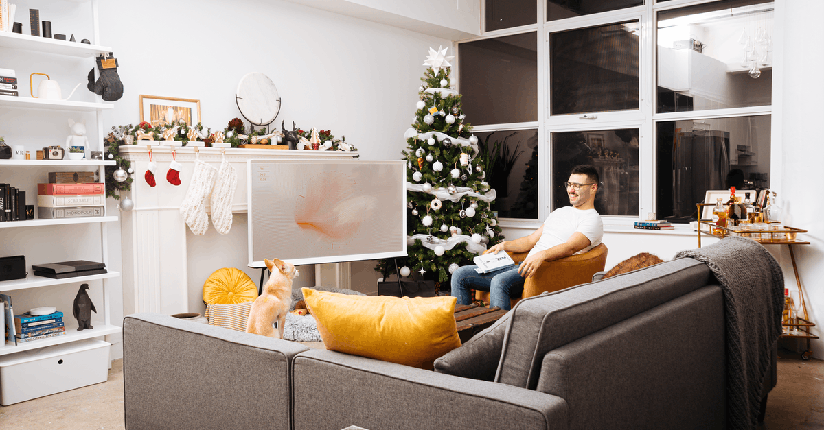 Connecting in Toronto on different airlines - Man Wearing White Crew-neck T-shirt and Eyeglasses Holding Book While Sitting on Chair Near Christmas Tree in Living Room