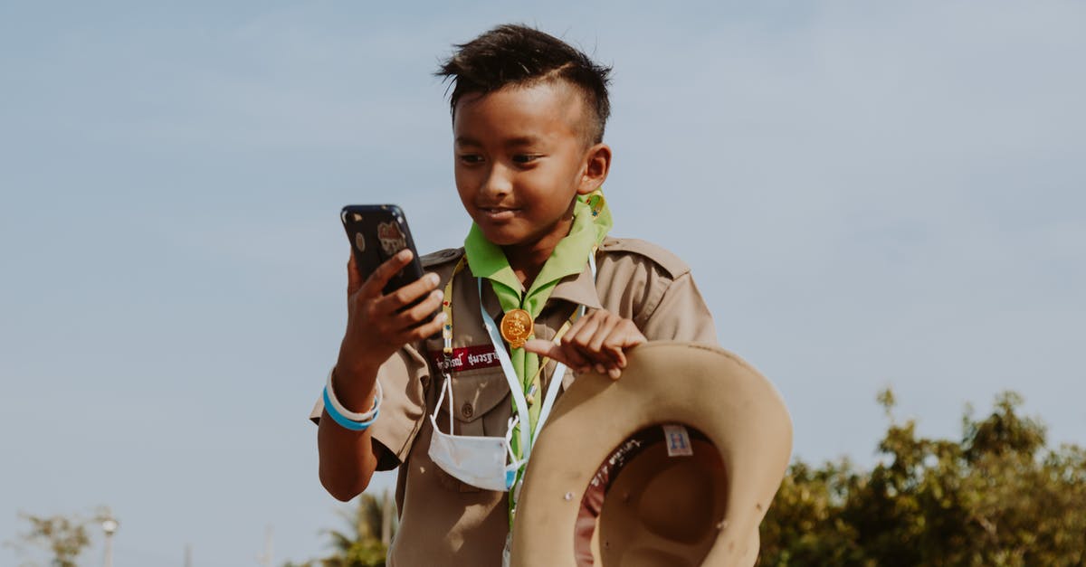 Connecting separate Airlines in Thailand - Boy Scout Looking at Smart Phone