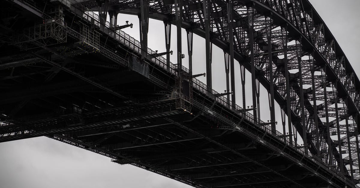 Connecting through Abu Dhabi with Etihad and Virgin Australia - Black and white from below famous Sydney Harbor Bridge with arch trusses beneath gloomy sky