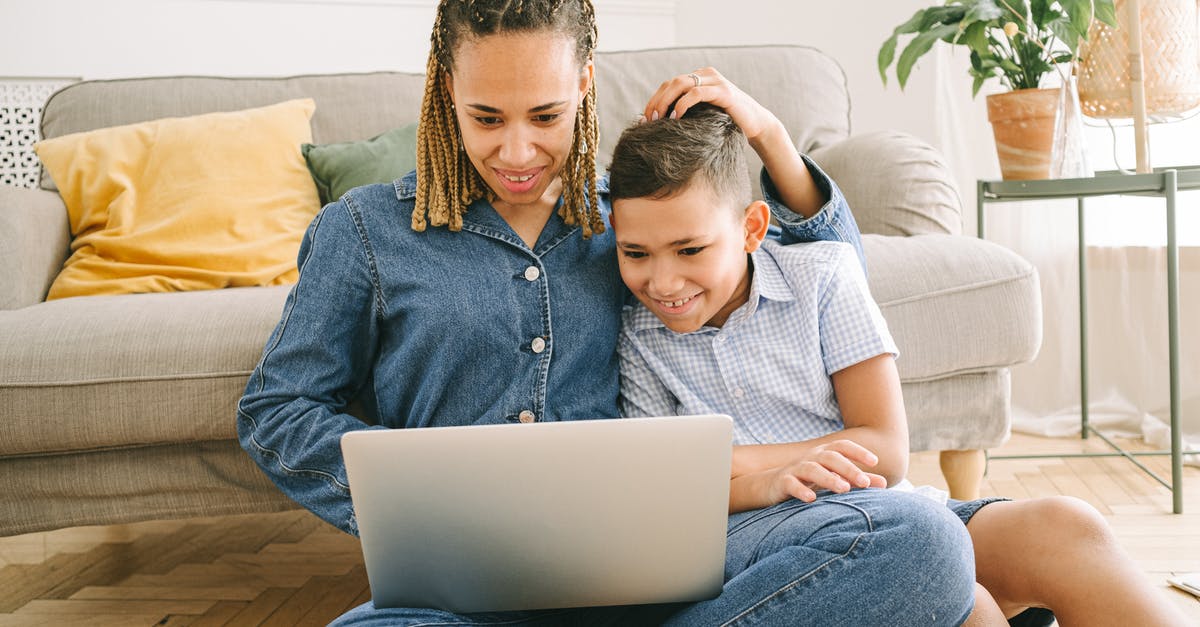 Consequences of accidentally holding onto two Indian passports simultaneously? - Woman and Young Boy Sitting on Floor with Laptop