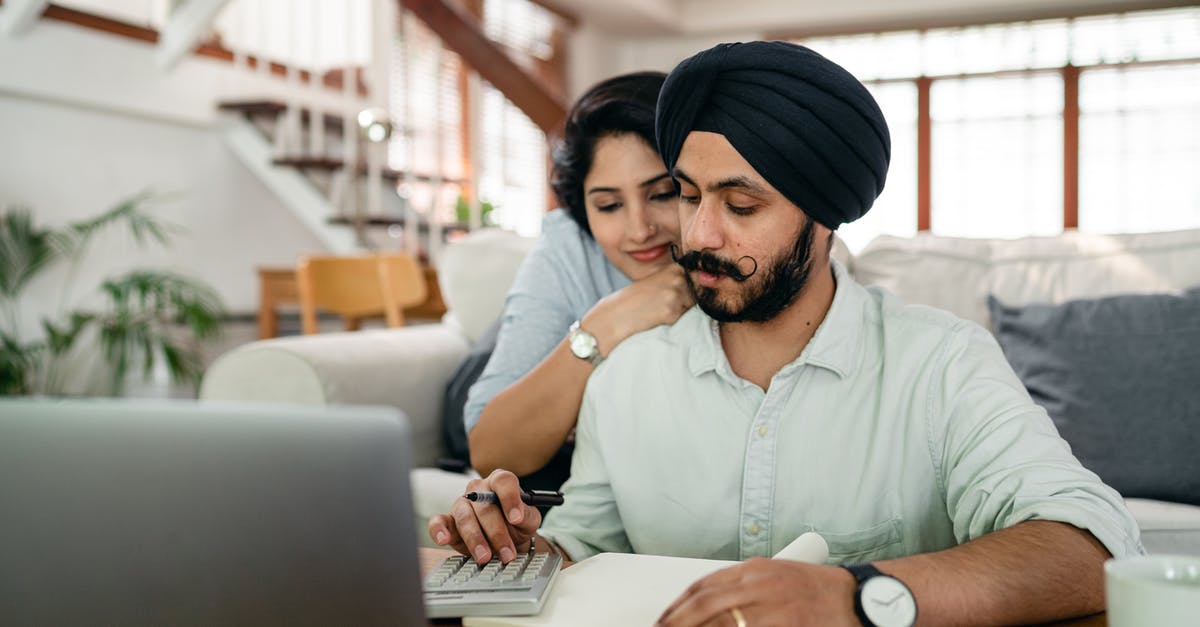 Converting Chinese spouse visa to work visa [closed] - Young smiling woman hugging concentrated husband from behind while counting bills on calculator in modern apartment