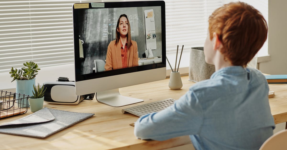 Coronavirus cancels connecting flight - Photo of Child Sitting by the Table While Looking at the Imac