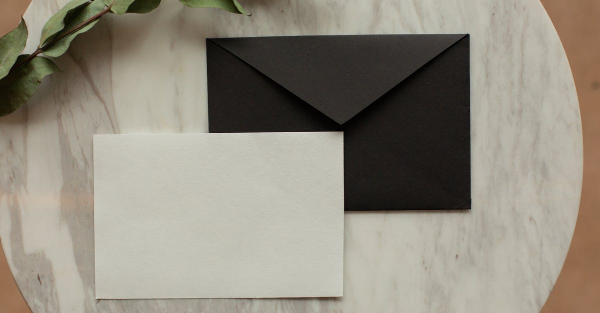 Covering Letter for Europe stay - Top view of blank black envelope with white card placed on table with pencil and dry green sprig in modern room