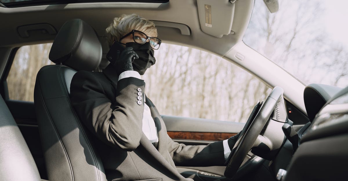 COVID-19: Does driving from Lee Vining to Fresno require a Yosemite Reservation? - From below side view of unrecognizable woman in formal clothes and protective mask and gloves talking on cellphone while driving contemporary car