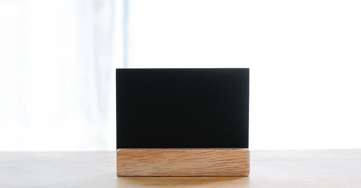 Credit card name mismatch because of long name - Empty black name card on wooden holder placed on desk in modern workplace