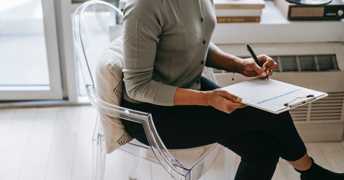 Crossing border from Spain to Morocco - possible problems? - From above of unrecognizable female psychologist with crossed legs taking notes on clipboard while filling out questionnaire during psychotherapy appointment in cozy office