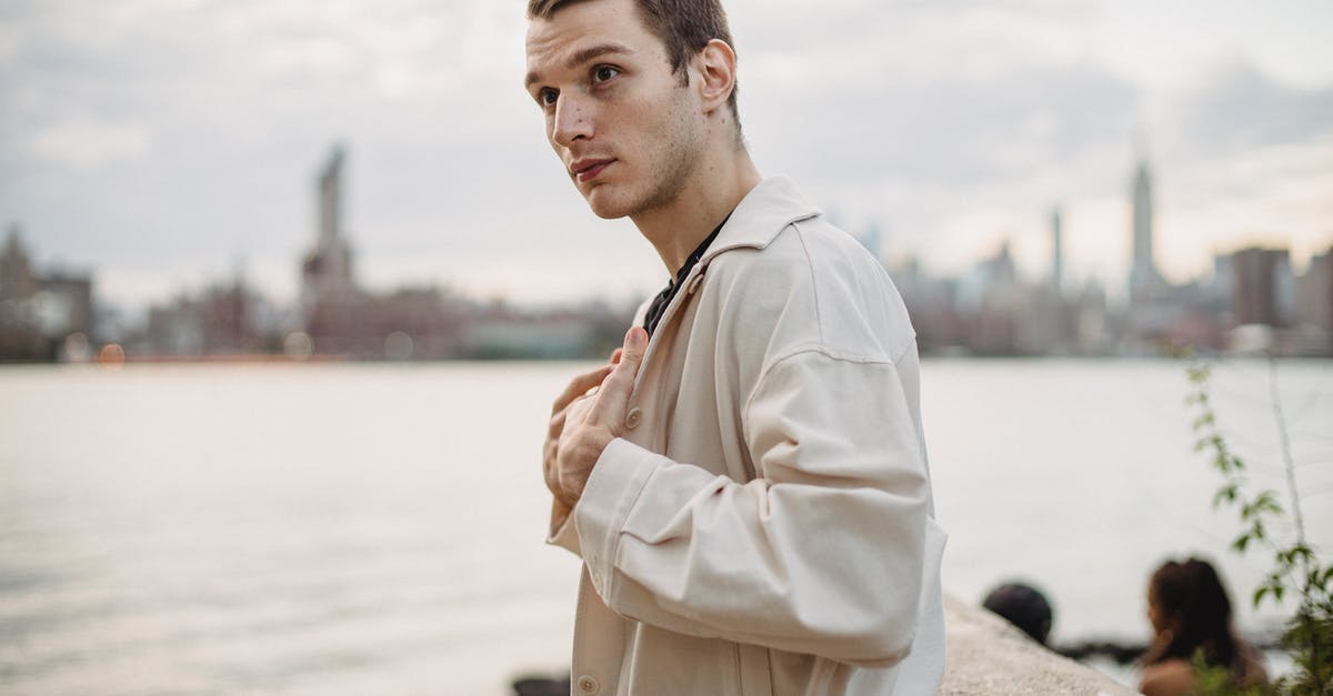 Crossing French-UK border under 18 alone - Side view of confident male wearing casual clothes standing near concrete border on river bank and looking away